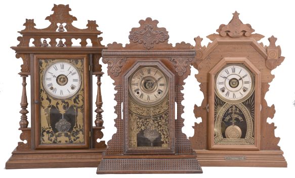 Clocks- 3 (Three): (1) E. N. Welch, "Gounod" mantel clock, 8 day, time and strike with alarm, spring driven movement in a black walnut case, c1889; (2) E. Ingraham, "Garnet" mantel clock, 8 day, time and strike with alarm, spring driven movement in an oak case, c1895; (3) Seth Thomas Clock Co., "Harvard" mantel clock variant, 8 day, time and strike with alarm, spring driven movement in a walnut case, c1893.