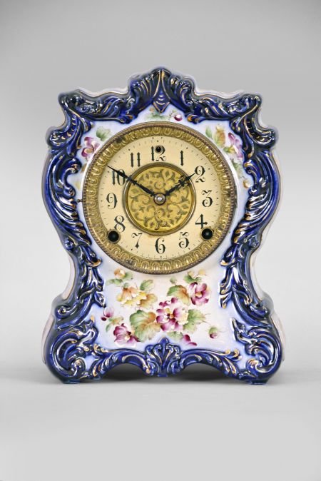 Clocks- 2 (Two) (1) William L. Gilbert Clock Co., Winsted, Conn., "No. 414", 8 day, time and strike spring brass movement porcelain mantel clock; (2) Ansonia Clock Co., New York, "Cabinet No. 51" mantel clock, 8 day, time and strike, spring driven movement in an oak case, brass dial with silvered chapter ring and cast spandrels, c1914.