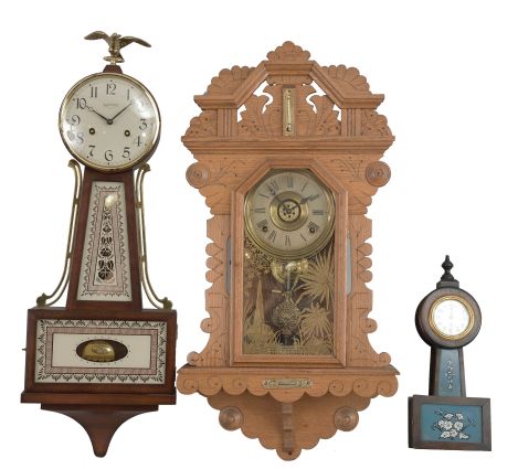 Clocks- 2 (Three) wall: (1) E. Ingraham, Bristol, Conn., "Crown Drop" hanging clock, 8 day, time and strike with alarm, spring driven movement in an oak case with thermometer and spirit level, c1895; (2) Waterbury Clock Co., "Alameda" miniature banjo clock, 30 hour, time only, spring driven balance wheel movement in a wood case with glass tablets, c1913; (3) New England Clock Co., Farmington, Conn., banjo clock, 8 day, time and strike, spring driven movement in a hardwood case, c1975.