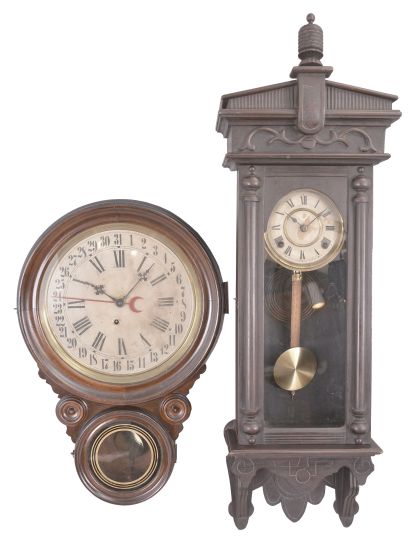 Clocks- 2 (Two) Wall: (1) E. Ingraham Clock Co., Bristol, Conn., "Meridian" hanging clock, 8 day, time and simple calendar, spring driven movement in a wood case with paper dial, c1900; (2) Japan, copy of Waterbury "Halifax" wall clock, 8 day, time and strike, spring driven movement in a stained hardwood case, c1900. .